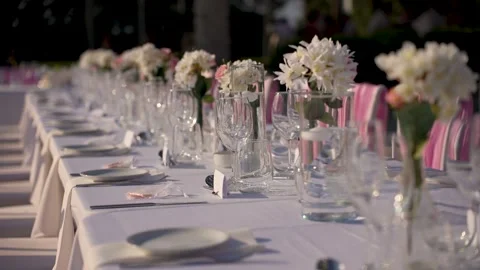 Elegant table setting for outdoor event with flowers in glass vases Stock Footage 341346562