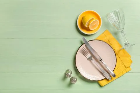 Elegant table setting with a pink plate silver cutlery yellow napkin and fres Stock-Fotos