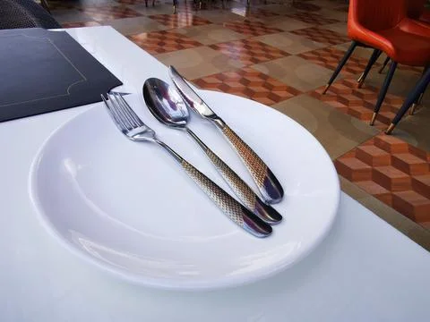 Elegant table setting in restaurant with empty plate and utensils. Stock Photos