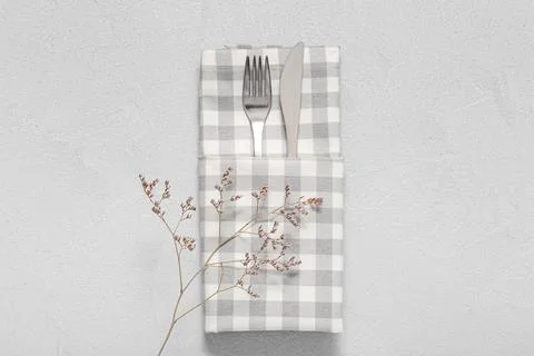 Elegant table setting with silverware and plaid napkin, minimalist dining arr Stock Photos