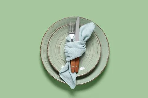Elegant table setting with two rustic green plates, light blue napkin, and wo Stock Photos