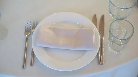 Elegant table setting with white plate, cutlery, and glassware for dining Stock Footage 290847353