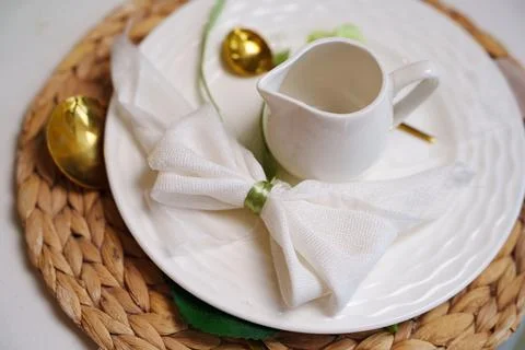 Elegant table setting with white plate, napkin bow and creamer 写真素材