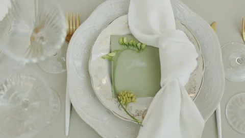 Elegant table setting with white plates and beautiful floral accents. Wedding Video stock 308398528