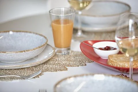 Elegant table setting with white plates, gold accents, glass of wine, and o.. Stock Photos