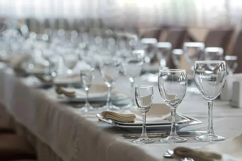 Elegant table setting with wine glasses and plates at dinner Stock Photos