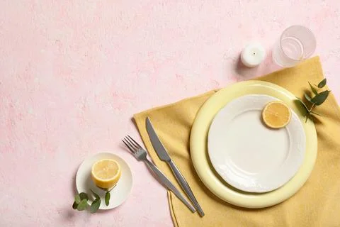 Elegant table setting with yellow plates, cutlery, lemon slices, and eucalypt Stock-Fotos