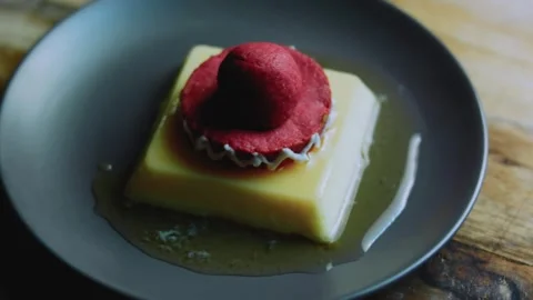 Elegant tabletop study of finished flan with playful sombrero decoration Stock Footage 342154156