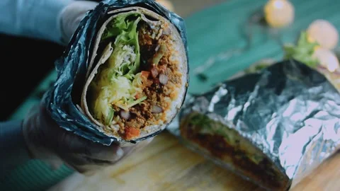 Elegant tabletop view: halved burrito revealing beef and vegetables Stock Footage 342168470