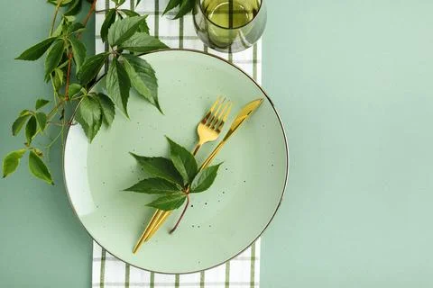 Elegant Thanksgiving Dinner Table Setting with Golden Cutlery and Green Lea.. Stock Photos