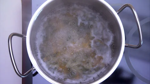 Elegant top-down video of boiling pasta in silver pan chef cooks in a kitchen Stock Footage 130394507