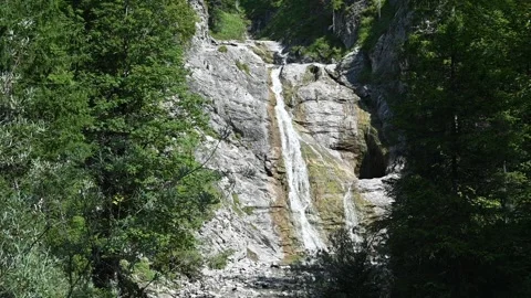 An elegant waterfall flowing down rocks (slow motion) Video stock 219631478