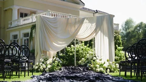 Elegant wedding ceremony setup with draped fabric and floral decorations Stock Footage 339582217