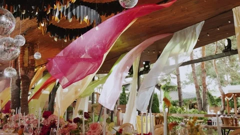 Elegant wedding decor featuring vibrant drapes, beautiful floral arrangements Stock Footage 323451448