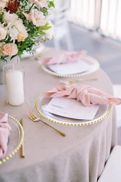 Elegant wedding dinner table setting with floral arrangement Stock Photos
