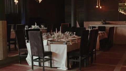 Elegant wedding reception hall with set tables glasses and candles Stock Footage 337495827