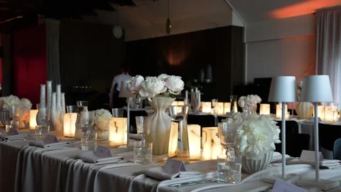 Elegant Wedding Reception Table with Candles and White Flowers in Warm Light Stockbeeldmateriaal 339044874