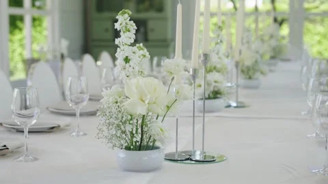Elegant wedding reception table decor with white flowers and candles Stock Footage 339458747