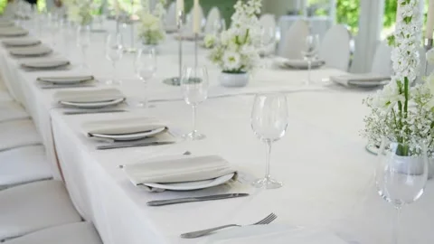 Elegant wedding reception table set with white linens and floral centerpieces Stock Footage 339458633