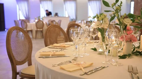 Elegant Wedding Reception Table Setting with Flowers and Glassware in Bright Stock Footage 336003368