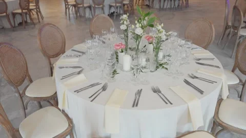 Elegant Wedding Reception Table Setting with Flowers and Glassware in Bright Stock Footage 336364699