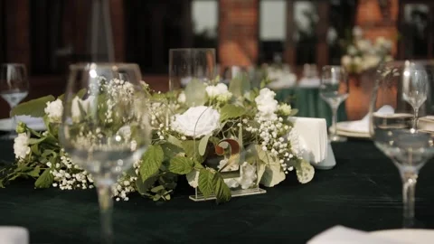 Elegant wedding reception table setting with floral centerpiece and glassware Stock Footage 338069311