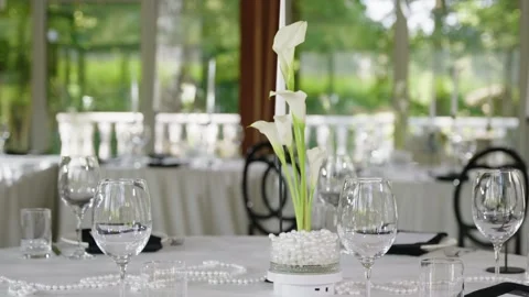 Elegant wedding reception table setting with floral centerpiece and glassware Stock Footage 339458152