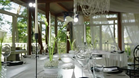 Elegant wedding reception table setting with floral arrangements and glassware Stock Footage 339458450