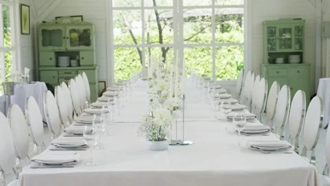 Elegant wedding reception table setting with floral centerpiece and glassware Stock Footage 339458540