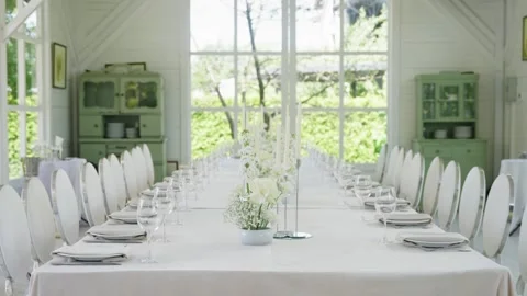 Elegant wedding reception table setting with floral centerpiece and glassware Stock Footage 339458831