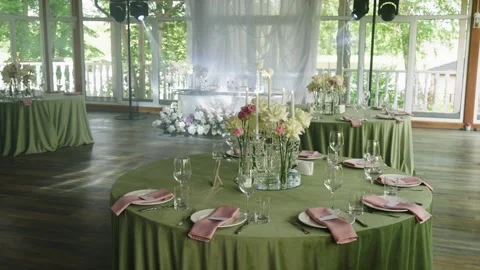 Elegant wedding reception tables adorned with floral centerpieces and glassware Stock Footage 339458281