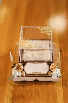 Elegant wedding ring box presentation with wooden base and golden accents Stock Photos