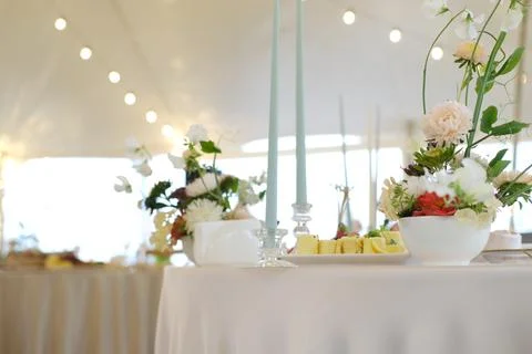 Elegant wedding table setting featuring floral arrangements, soft candlelight Stock Photos