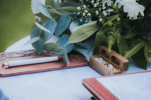 Elegant wedding table setting featuring a floral arrangement, a white pen, .. Stock Photos