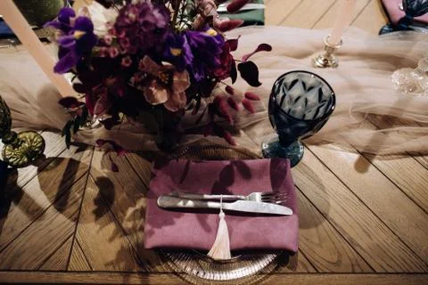Elegant wedding table setting with silver fork and knife on purple cloth Stock Photos