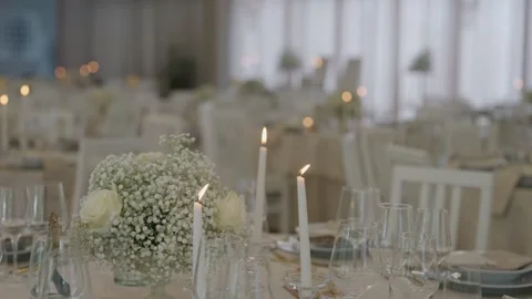 Elegant wedding table setting with white flowers and lit candles Stock Footage 337582388
