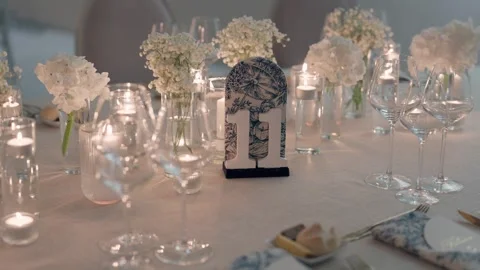 Elegant Wedding Table Setting With White Flowers And Glowing Candles Stock Footage 337777920