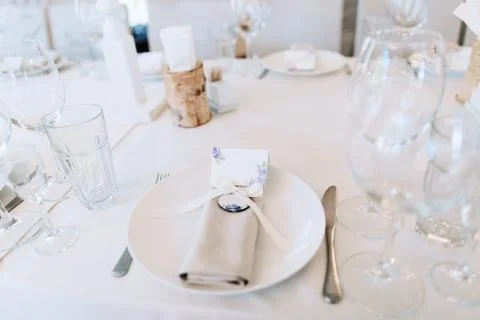 Elegant wedding table setting in white with silverware Stock Photos