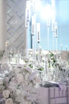 Elegant wedding table setting with white flowers and tall candle holders Stock Photos