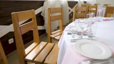 Elegant Wedding Table Setting with Wooden Chairs and Pink Napkins Stock Footage 342030730