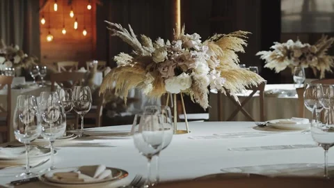 Elegant Wedding Table Setup with Floral Centerpieces and Soft Lighting for a Stock Footage 306295498