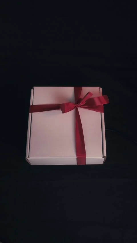 Elegant White Gift Box with Red Ribbon Bow on Dark Background Stock Footage 323453474