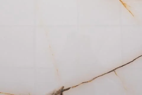 Elegant white marble surface with subtle golden veins and a smooth finish in a 스톡 사진