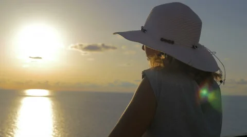 Elegant woman with hat while observing the sunset Video stock 67813730