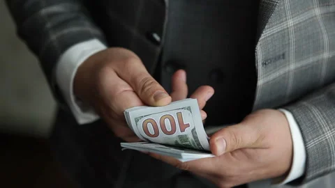 An elegant young man holding a bundle of American dollar bills Stock Footage 164832863