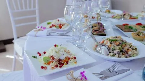 Elegantly arranged dining table featuring gourmet salads, sprinkled with Stock Photos