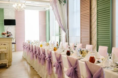 An elegantly decorated long dining table set for a celebration, featuring Stock Photos