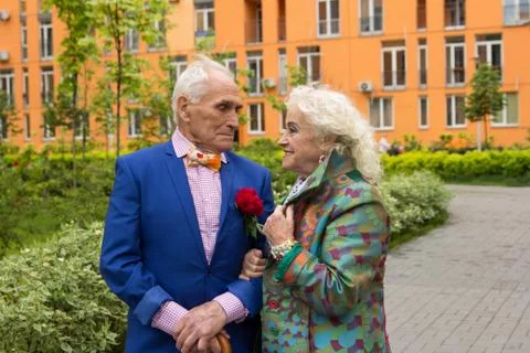 Elegantly dressed elderly couple walking outdoors Stock Photos