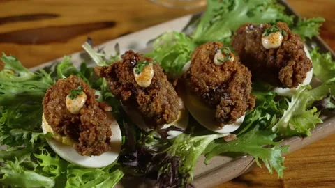 Elegantly plated deviled eggs topped with fried oysters and aioli sitting Stock Footage 175027232