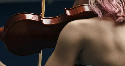 Elegantly plays violin, blue setting, lips red Stock Footage 276639866